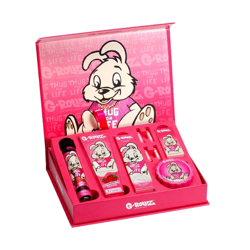 G-ROLLZ Gift Box Thug for Life XS, geöffnete pinke Geschenkbox mit Banksy-Graffiti-Hasen-Motiv und arrangiertem Set-Inhalt aus Cones, Papers, Tips, Box und Grinder